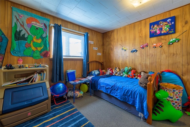 carpeted bedroom featuring wooden walls