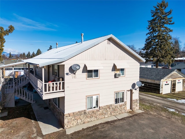 view of home's exterior featuring cooling unit and stone siding