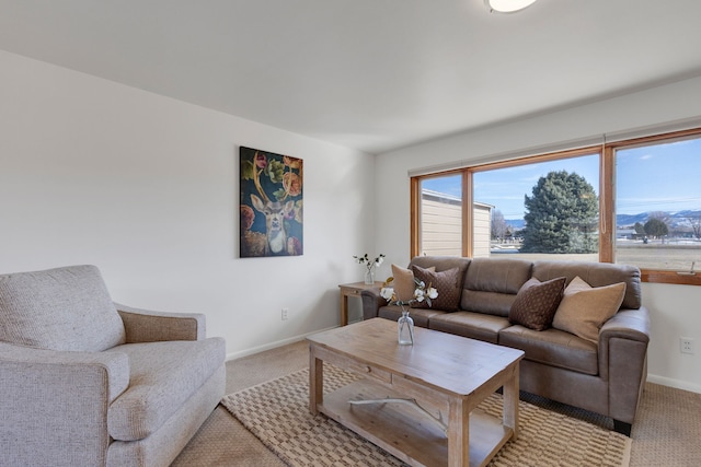 living area featuring baseboards and light colored carpet