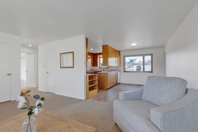 living area featuring light colored carpet and baseboards