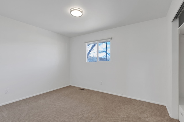 carpeted empty room with visible vents and baseboards