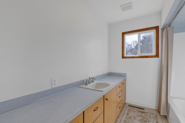 full bath with visible vents, vanity, and baseboards