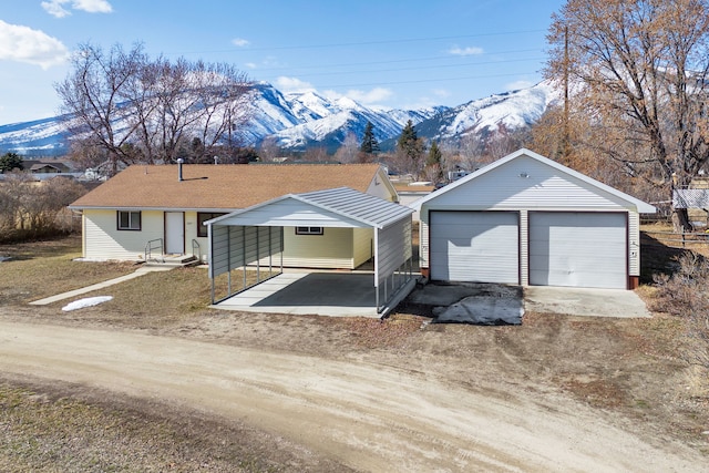 ranch-style house featuring an outdoor structure, a garage, and a mountain view