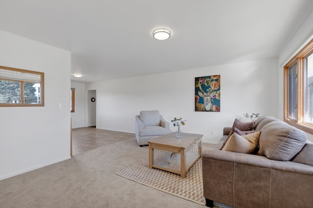 living area with baseboards and light carpet