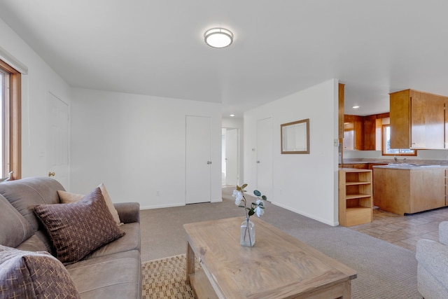 living room with light tile patterned flooring, recessed lighting, light colored carpet, and baseboards