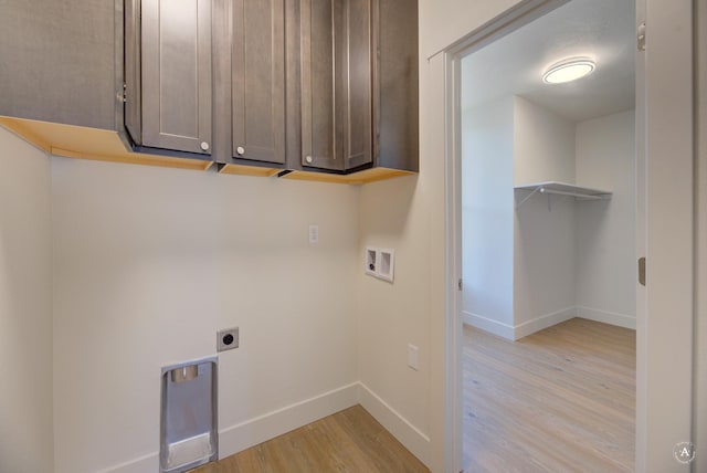 washroom with light wood finished floors, baseboards, washer hookup, cabinet space, and hookup for an electric dryer