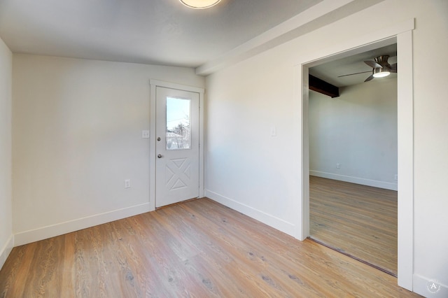 unfurnished room with baseboards, light wood-style floors, and a ceiling fan