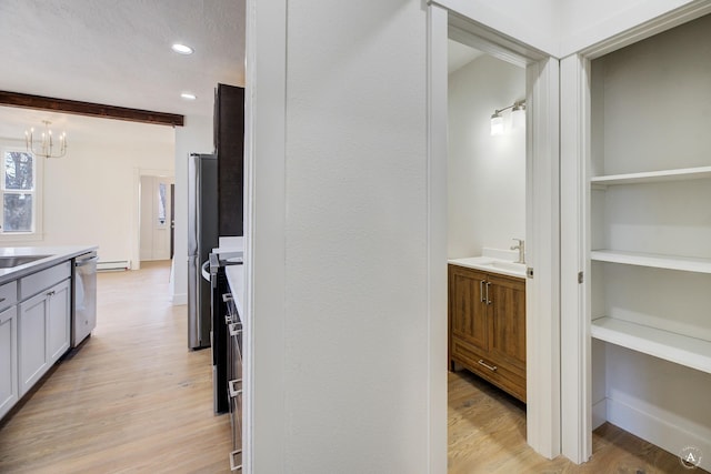 hall featuring a sink, light wood-type flooring, recessed lighting, and a baseboard radiator