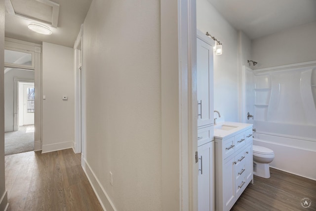 hall with a sink, baseboards, attic access, and dark wood-style flooring