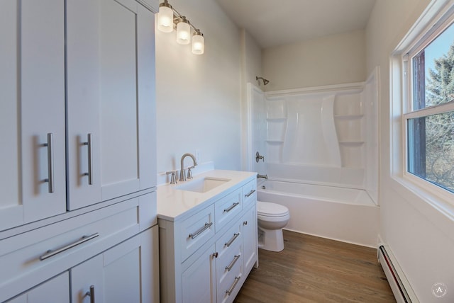 bathroom with a baseboard radiator, toilet, a healthy amount of sunlight, and wood finished floors