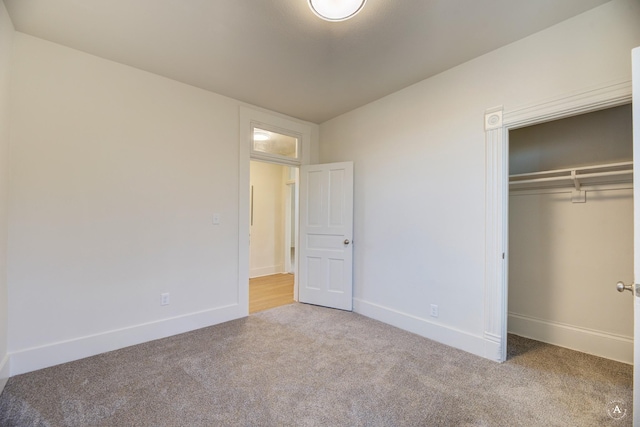 unfurnished bedroom with a closet, carpet flooring, and baseboards