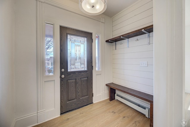 mudroom with a baseboard heating unit, wooden walls, and light wood-style flooring