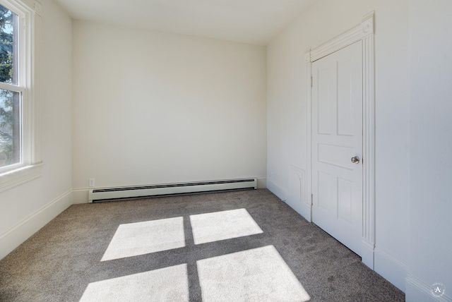 spare room featuring a baseboard heating unit and carpet floors