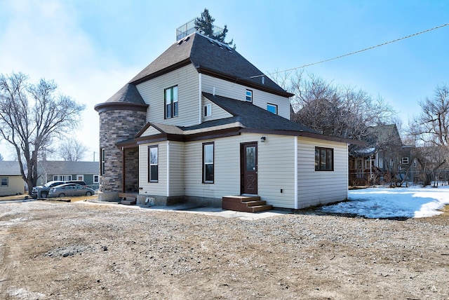 back of property featuring stone siding