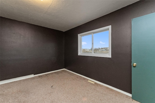 carpeted empty room featuring visible vents, baseboards, and a textured ceiling