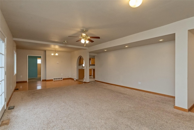 unfurnished room with ceiling fan with notable chandelier, visible vents, carpet floors, and baseboards