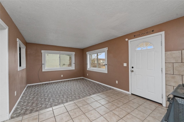 foyer with a textured ceiling and light carpet