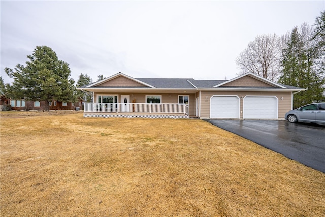 ranch-style house with aphalt driveway, an attached garage, covered porch, and a front lawn