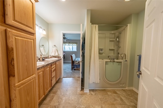 bathroom with a sink, a shower with shower curtain, double vanity, baseboards, and ceiling fan