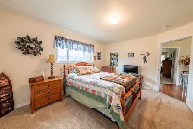 bedroom featuring light colored carpet and baseboards