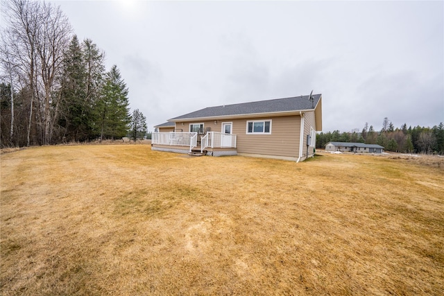 back of house with a wooden deck and a lawn