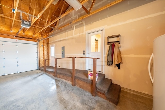 garage featuring electric panel, a garage door opener, and freestanding refrigerator