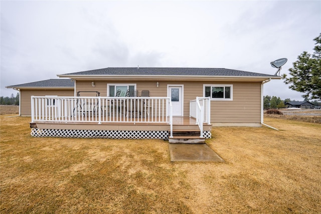 rear view of property with a deck and a yard