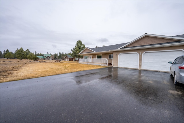 ranch-style home featuring aphalt driveway and a garage