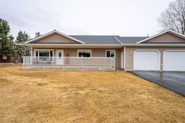 ranch-style house featuring aphalt driveway, a garage, covered porch, and a front yard