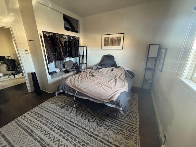 bedroom with a closet and dark wood-style floors