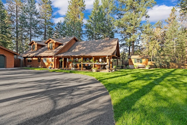 32 Peaceful Ct, Bigfork, MT 59911 - log-style house featuring an outbuilding, covered porch, log siding, and asphalt driveway