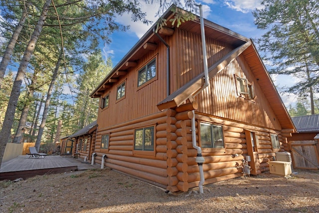 32 Peaceful Ct, Bigfork, MT 59911 - view of side of home featuring a wooden deck, board and batten siding, and log exterior