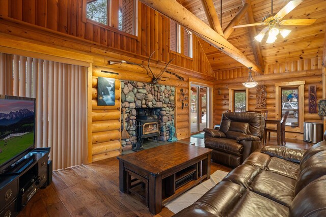 32 Peaceful Ct, Bigfork, MT 59911 - living area with hardwood / wood-style floors, a wood stove, rustic walls, a wood ceiling with exposed beams, and high vaulted ceiling