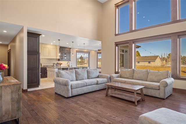 living room featuring dark wood-style floors, recessed lighting, and a high ceiling