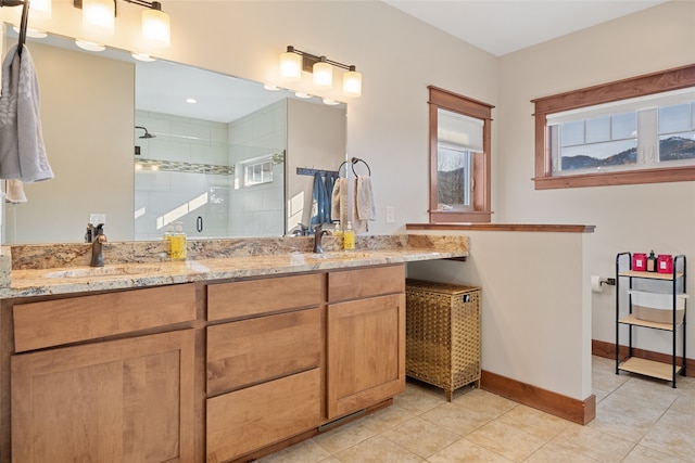 full bathroom with baseboards, double vanity, a sink, a shower stall, and tile patterned floors