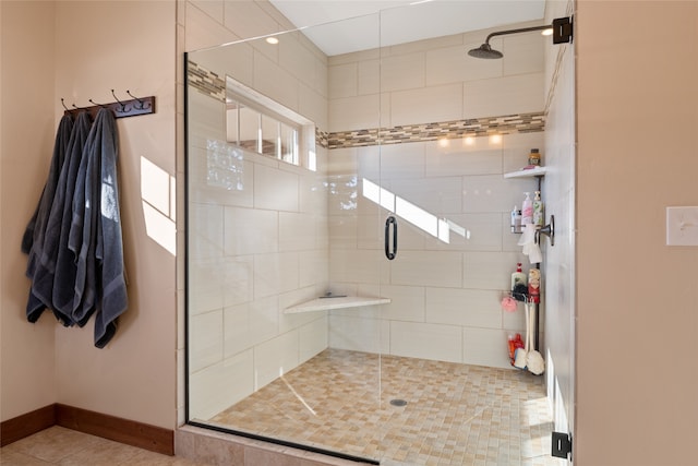 bathroom featuring tile patterned flooring, baseboards, and a stall shower