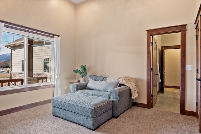 sitting room featuring a high ceiling, carpet flooring, and baseboards