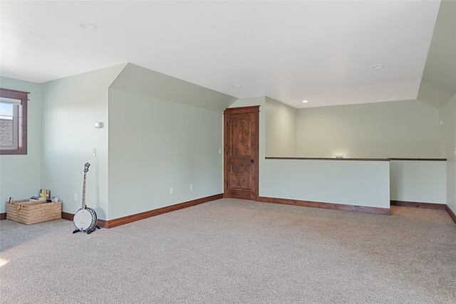 unfurnished room with baseboards, carpet, and vaulted ceiling