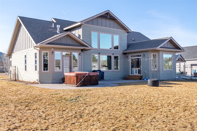 rear view of property with a patio, entry steps, board and batten siding, and a hot tub