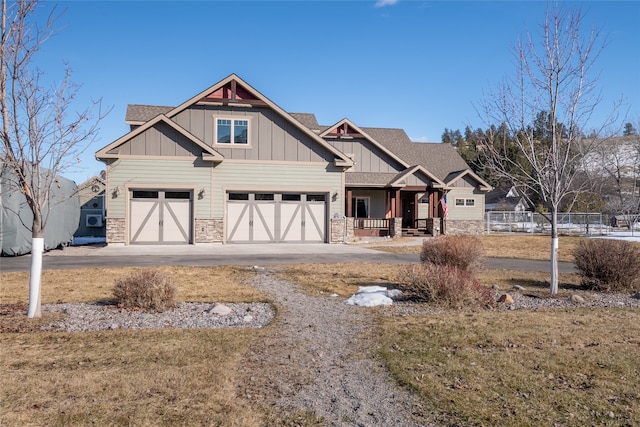 craftsman-style house with board and batten siding, a shingled roof, concrete driveway, stone siding, and an attached garage