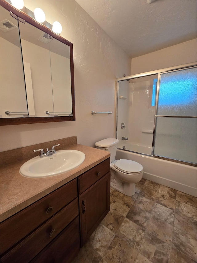 full bathroom featuring combined bath / shower with glass door, visible vents, toilet, and vanity