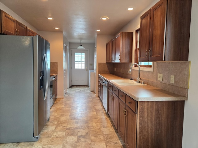 kitchen featuring a sink, backsplash, recessed lighting, appliances with stainless steel finishes, and light countertops