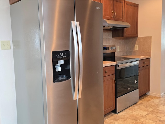 kitchen featuring under cabinet range hood, backsplash, stainless steel appliances, brown cabinetry, and light countertops