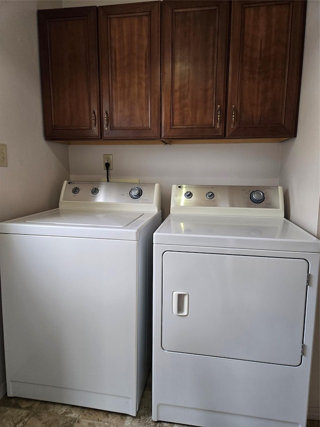 clothes washing area with cabinet space and separate washer and dryer