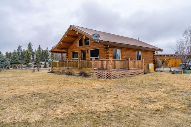 view of front of home with log siding, metal roof, and a front yard