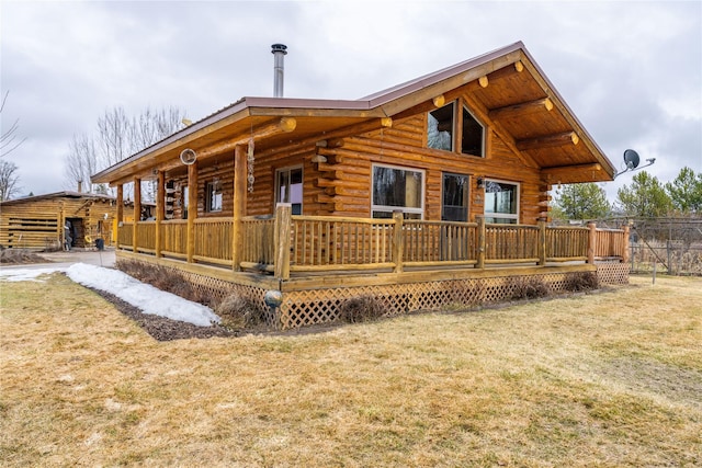 back of house with log exterior and a lawn