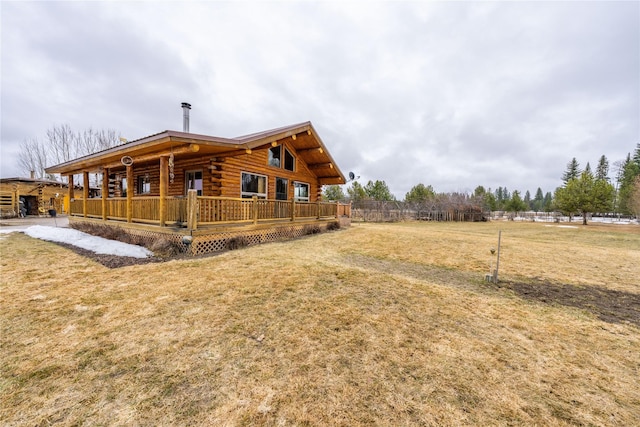 view of side of property with log siding and a yard