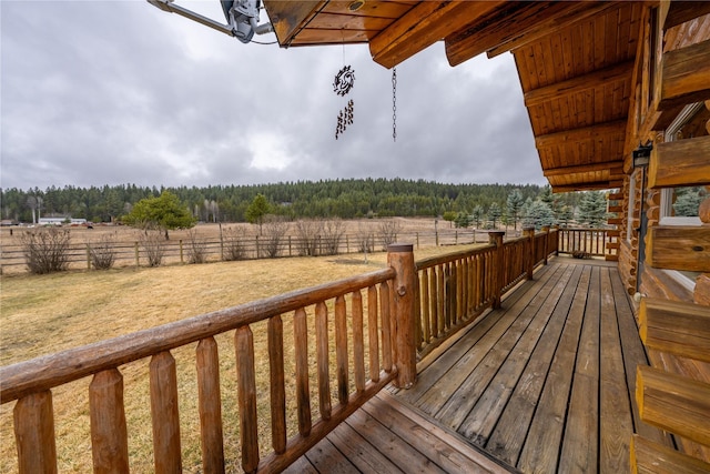 wooden terrace featuring a rural view and a view of trees