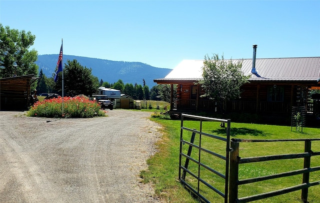 view of street featuring a mountain view, driveway, and a gated entry