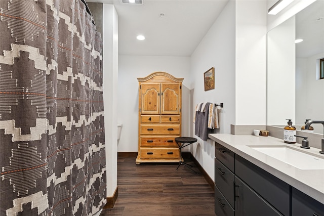 bathroom featuring vanity, a shower with curtain, wood finished floors, visible vents, and baseboards